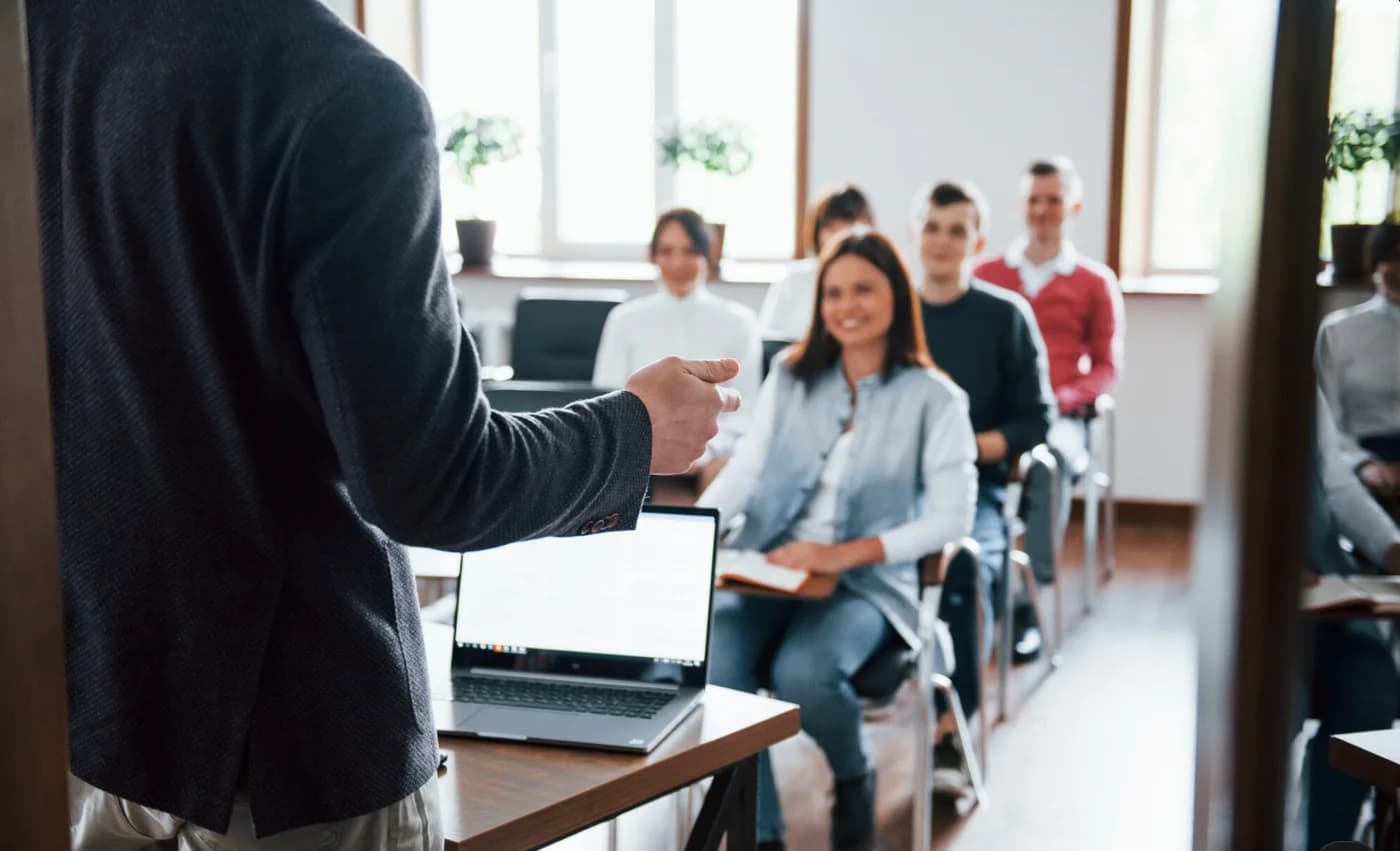 A trainer leads a session in front of a group of learners